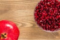 A bowel of pomegranate seeds beside a whole pomegranate fruit. Royalty Free Stock Photo