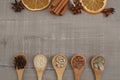 Seeds on wooden spoons. Top view of dried orange, cinnamon, star anise on gray background Royalty Free Stock Photo