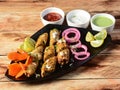Seekh kabab - Pakistani spicy grilled ground meat skewers, served over a rustic wooden table, selective focus