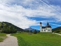 Seekirchl Church in open green area in Seefeld Austria and pathway leading beyond