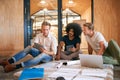 This seems like a trend we can capitalise on...a team of designers brainstorming on the floor in an office. Royalty Free Stock Photo