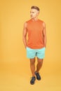 Seems like very confident and handsome. Confident sportsman orange background. Confident look of muscular guy. Athletic