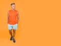 Seems like very confident and handsome. Confident sportsman orange background. Confident look of muscular guy. Athletic