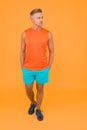 Seems like very confident and handsome. Confident sportsman orange background. Confident look of muscular guy. Athletic