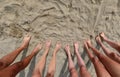 Seen from above ten barefoot feet on the sandy beach of a family with five people Royalty Free Stock Photo