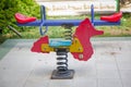 Seesaw on child playground in park. childs horse ride in the playground .Swing on a metal spiral . Spring horse in the playground Royalty Free Stock Photo