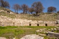 Trees and grass around ancient Teos theatre with steps on the slopes of Acropolis from Roman Greek period Royalty Free Stock Photo