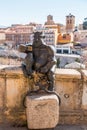 Devil statue taking a selfie against the ancient Roman aqueduct of Segovia, Spain