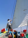 Seixal, Portugal. June 20, 2023: Sailors hoisting or setting the main sail on the sailboat Amoroso, a historical, typical or