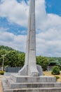 Concrete tower memorial under blue cloudy sky in public park