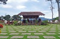 Wooden terrace hut facing tropical forest.