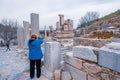Old woman taking photo of remnants in Ephesus ruins, historical ancient Roman archaeological sites in eastern Mediterranean Ionia