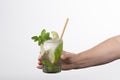 Select focus of a tempting mojito cocktail being held by a male hand on a light background