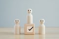 Select happy face figure on top of wooden blocks. choosing positive attitude to team leader.