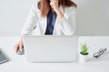 Selected focus businesswoman pose hand on chin and holding mouse and working on white desk modern office Royalty Free Stock Photo