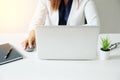 Selected focus laptop with woman hand holding on mouse and working on white desk modern office