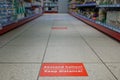 Keep distance on red rectangular caution sign inside supermarket in Germany during epidemic COVID-19. Royalty Free Stock Photo