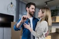 Selected focus, married couple man and woman happy together, hugging, holding the keys to their new apartment, housewarming, close Royalty Free Stock Photo