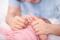 Selected focus on mother hands holds little baby covered by pink Royalty Free Stock Photo