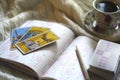 Selected focus of tarot cards layout, cup of Coffee and notebook. Royalty Free Stock Photo