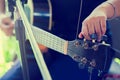 Selectice to hand guitarist adjusting pegs on acoustic guitar during music lesson at home Royalty Free Stock Photo