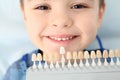 Selecting cute boy`s teeth color with palette in clinic. Royalty Free Stock Photo