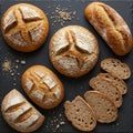 A selection of artisanal bread on a dark slate surface. Three round loaves with distinct Royalty Free Stock Photo