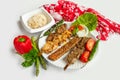 Selection of BBQ chicken tikka and seekh kebabs served with rice salad in a dish isolated on colorful table cloth top view on grey