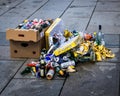 Selection of beer bottles and boxes on a concrete sidewalk after an outdoor party