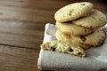 Selection of choc chip and fruit cookies, on a serviette on a wooden table. Copy space for text Royalty Free Stock Photo