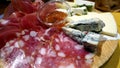 Selection of cold cuts and fresh and aged cheeses on a wooden cutting board Royalty Free Stock Photo
