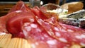 Selection of cold cuts and fresh and aged cheeses on a wooden cutting board Royalty Free Stock Photo