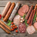 Selection of cold meats, including a variety of processed cold meat products, displayed on a wooden background. Royalty Free Stock Photo