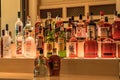 Selection of colorful liquor alcohol bottles line the shelf of a