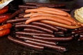 Selection of wiener sausages on cast iron griddle. Royalty Free Stock Photo