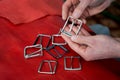 Craftsman hands and metal buckles top view on red leather background. Accessories for Royalty Free Stock Photo