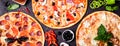 Selection of different pizzas on a black background and ingredients. Peperoni, Vegetarian and Seafood Pizza Royalty Free Stock Photo