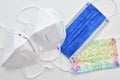 a selection of different protective face masks - ffp2 kn95 surgical children - on white laboratory surface