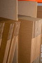 A selection of flat shipping boxes/cartons on a shelf ready to be made up and packed with product. Warehouse, despatch, shipping,