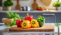 A selection of fresh fruit: bell pepper, sitting on a chopping board against blurred kitchen background copy space