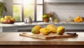 A selection of fresh fruit: mango, sitting on a chopping board against blurred kitchen background copy space