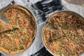 Selection of freshly-baked pies arranged on white paper with knives, ready to be enjoyed