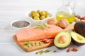 Selection of healthy unsaturated fats, omega 3 - fish, avocado, olives, nuts and seeds. Royalty Free Stock Photo