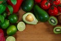 A selection of juicy fruits and vegetables on a wooden and white background. Royalty Free Stock Photo