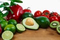 A selection of juicy fruits and vegetables on a wooden and white background. Royalty Free Stock Photo