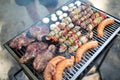 Selection of meat grilling over the coals on a portable barbecue
