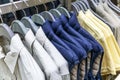 A selection of men\'s casual clothes on hangers in a store. Shirts, jackets and T-shirts on hangers. Royalty Free Stock Photo