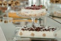 several layered cakes on glass platters are in various sizes
