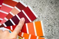 Selection of the paint color for decorative home repairs to the palette with layouts. A fan of shades in your hand inside the home