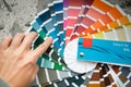 Selection of the paint color for decorative home repairs to the palette with layouts. A fan of shades in your hand inside the home